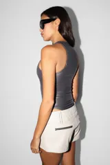 Body gris de microfibra con textura PU, corte ajustado y escote deportivo. Cuenta con broches snap en la entrepierna y elástico interno en el contorno de tiro para un mejor ajuste.