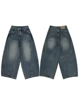 Pantalón de jean de corte extremadamente ancho (hiper baggy) con lavado oscuro y efecto desgastado. Presenta costuras marcadas en el frente y bolsillos delanteros y traseros.