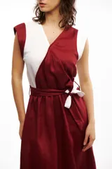 Vestido midi de lino bicolor, blanco y rojo, con escote cruzado tipo kimono y lazo en la cintura. Sin mangas y falda midi.