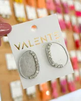 Par de aros colgantes con forma irregular, de acrílico color plateado con borde de strass.