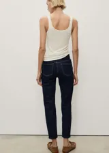 Pantalón de jean azul oscuro, tiro alto, corte mom fit, cinco bolsillos y cierre con cremallera y botón.