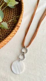 Collar de tiento marrón con doble aro labrado y colgante de nácar.