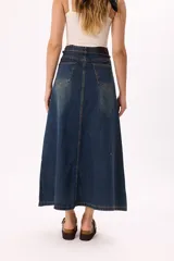 Falda larga de denim azul con lavado vintage, corte evasé, tajo frontal y cintura con lazo ajustable.