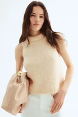 Top sin mangas color crema, tejido en punto suave con mohair y lana.