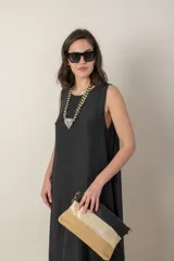 Vestido midi marrón de tejido tramado, corte suelto, sin mangas y con bolsillos laterales.