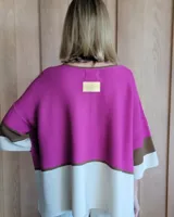 Buzo de punto con mangas 3/4, corte amplio y diseño a bloques de color negro, gris y blanco.