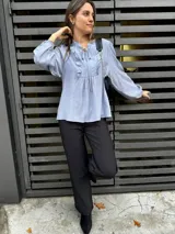 Blusa rosa de mangas largas con puños elásticos, escote en V con volados y lazos.
