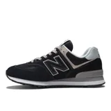 Championes urbanos New Balance modelo 574, color negro con detalles en gris y beige, confeccionados en gamuza y malla, con logo "N" característico en los laterales y entresuela ENCAP.