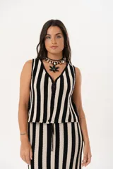 Chaleco tejido a rayas verticales en color negro y crudo, con escote en V y cierre frontal con ganchitos.