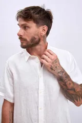 Camisa celeste de lino, de corte clásico, manga corta y cuello italiano.