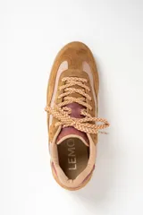 Zapatilla deportiva de caña baja, con paneles combinados en gamuza color camel y material liso color rosado pálido. El cuello y el talón son de color vino o rosado oscuro. Cordones trenzados en tonos beige y naranja. Suela de goma color camel.