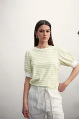 Remera de manga corta con cuello redondo y estampado de rayas horizontales blancas y negras. Mangas abullonadas con puño blanco.