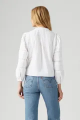 Camisa blanca de mangas largas con detalles de encaje en el frente y en las mangas.