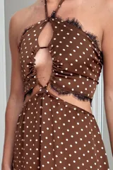 Vestido largo con estampado paisley en tonos tierra y azules, con top halter y cut-outs laterales. La falda es holgada y tiene elástico en la cintura.