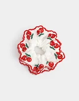 Maxi scrunchie blanco con bordado de cerezas rojas y borde festoneado rojo.