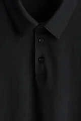 Remera polo negra de manga corta en piqué liviano de mezcla de algodón con cuello y tapeta de botones. Corte ajustado que realza el contorno del cuerpo creando una silueta entallada. Confeccionada con tejido funcional COOLMAX®, una fibra exclusiva de poliéster de secado rápido que elimina la humedad y regula la temperatura corporal proporcionando un ajuste cómodo y suave.