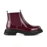 Bota Chelsea de charol negro con elástico lateral, suela track y tirador trasero.