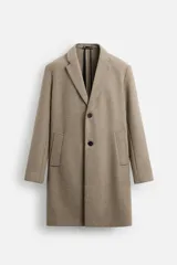 Abrigo recto color beige confeccionado en tejido con lana. Tiene cuello con solapas de muesca, manga larga con puños abotonados, bolsillos de vivo en la cadera, bolsillo interior, abertura en el centro de la espalda y cierre frontal con botonadura.