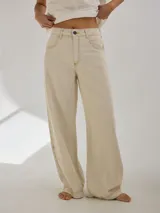 Pantalón gris de tiro medio alto, corte ancho, con bolsillos delanteros y traseros, detalles de atraques y triples costuras en color amarillo.