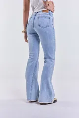 Pantalón de jean celeste de tiro medio, corte ajustado hasta la rodilla y acampanado en la parte inferior, con lycra y terminación desflecada.