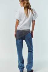 Camiseta blanca de algodón con cuello redondo y mangas cortas con vuelta, trabilla y botón.