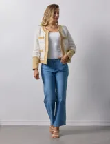 Chaqueta Nanette en tejido tweed color crudo con detalles en denim azul. Tiene cuello a la base, abertura central, bolsillos delanteros, puños con aplique de botones perlados, terminación desflecada y forro interno.