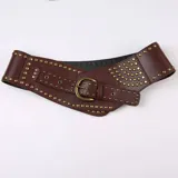 Cinturón ancho de cuero sintético color marrón con tachas doradas y hebilla metálica.
