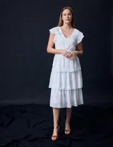 Vestido blanco de gasa con capas de la marca Julia Jordan. Tiene escote en V, mangas cortas con volados, corte en la cintura, abertura central en la espalda con cierre invisible y forro interno a tono.