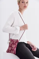 Bolso pequeño tipo cartera porta celular confeccionado en terciopelo color borgoña, con diseño bordado de tulipanes dorados. Tiene acceso superior con cierre y tirante en hilo metalizado, más cordón largo que permite colgarlo al cuerpo.