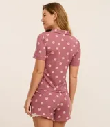 Conjunto de pijama americano corto, color rosado con estampado de caracolas. Incluye camisa de manga corta con cuello solapa y abotonado delantero, y short con cintura elástica y detalle de encaje en el ruedo.