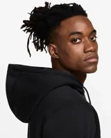 Campera negra con capucha y cierre frontal, con logo de Nike bordado en blanco en el puño izquierdo y una letra N grande en el pecho con borde naranja y relleno azul.