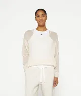 Suéter color crema de punto fino con cuello en V y corte holgado, confeccionado en mezcla de lana de alpaca. Presenta puños de punto acanalado y un logotipo de mini rayas bordado en la espalda, justo debajo del escote.