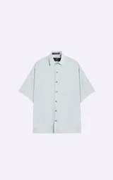 Camisa celeste de manga corta con calce oversize y canesú en la espalda.