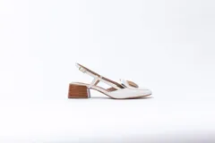 Zapato de cuero blanco con taco de madera, talón descubierto y pulsera con hebilla. Aplique decorativo en la capellada.