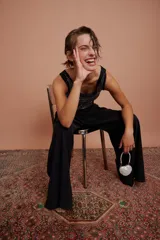 Body negro con escote redondo y apliques de strass plateados en el frente. Presenta corte cut-out en los laterales y cierre con lazos.