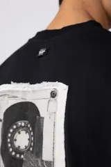 Remera color crema de corte oversize con la palabra "Rewind" bordada en el frente.