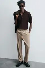 Pantalón color topo de corte recto, con cintura elástica ajustable con cordón, bolsillos laterales y bolsillos de vivo en la espalda.