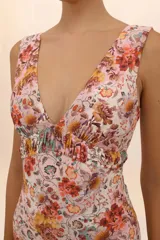 Traje de baño entero con estampado floral en tonos naranja, amarillo y celeste. Tiene escote en V y cintura fruncida.