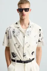 Camisa de manga corta con cuello bowling y estampado floral en tonos blanco y negro.