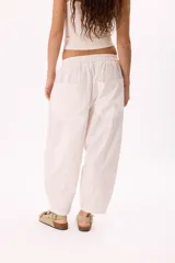 Pantalón blanco de tela ligera con cintura elastizada, calce relaxed y bolsillos laterales.