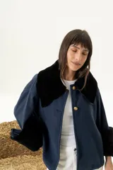 Sobre camisa azul marino en paño de lana con cuello y puños en cuero napalan negro, con botones dorados.