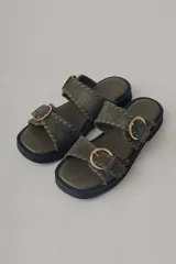 Sandalias de plataforma color verde militar, confeccionadas en cuero, con doble tira ancha con hebillas doradas y suela de goma negra.