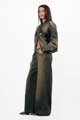 Campera de jean azul con lavado matizado, corte regular, acceso con botones personalizados, bolsillos delanteros con tapa y bolsillos laterales funcionales. Cada prenda es elaborada de manera artesanal, lo que las distingue unas de otras. Los tonos en el lavado pueden variar desde claros hasta oscuros.