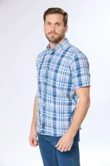 Camisa de manga corta con cuello abotonado y estampado a cuadros en tonos de azul y blanco. Hecha en Uruguay.