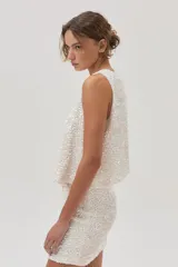 Minifalda de lentejuelas color blanco sobre base de terciopelo ligero.