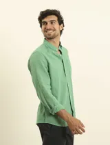 Camisa azul marino de lino y algodón, con cuello abotonado, manga larga con puños enrollados, bolsillo de parche en el pecho y cierre frontal con botones.