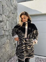 Buzo de polar con cuello alto, cierre de botones a presión y estampado de cebra en tonos beige y negro.