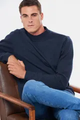 Buzo tejido de lana azul, con cuello alto, detalle en cuero y logo bordado.