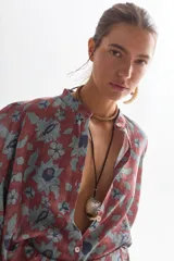 Camisa de lino color ladrillo con estampado de flores azules, cuello mao, mangas largas abullonadas con puño elástico y corte holgado.