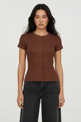 Saco de algodón y elastano color marrón, de corte ajustado, con cuello redondo, manga corta y cierre frontal de botones.